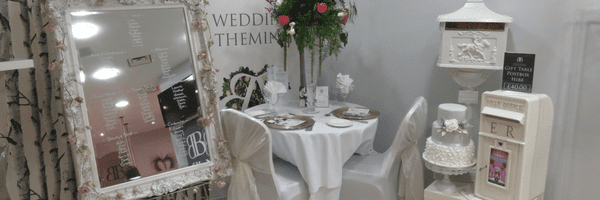 Inside the flower shop, a table set with chairs with bows