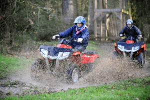 Two people quad biking through a puddle