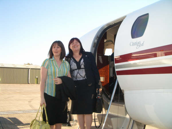 Two woman walking onto a private jet 