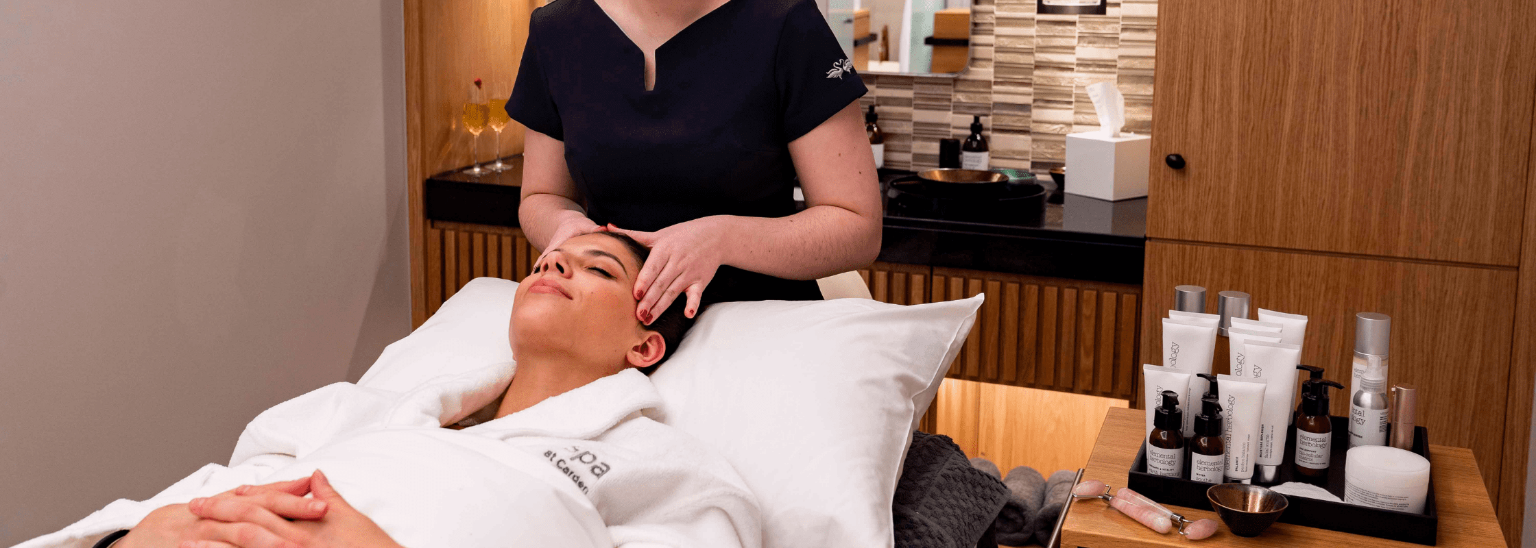 A woman getting her head massaged by a spa therapist